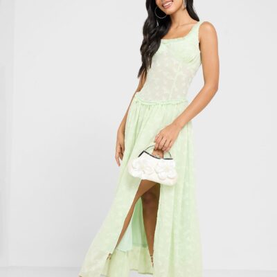 This light green chiffon dress features a subtle floral pattern, a fitted bodice, and a flowing